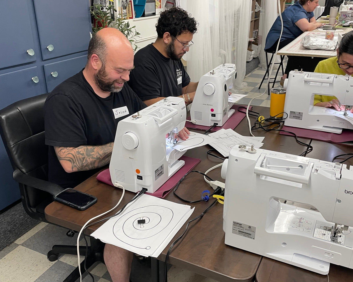 Colleagues sewing together during a corporate team building event at Unfold Den's Denver studio.