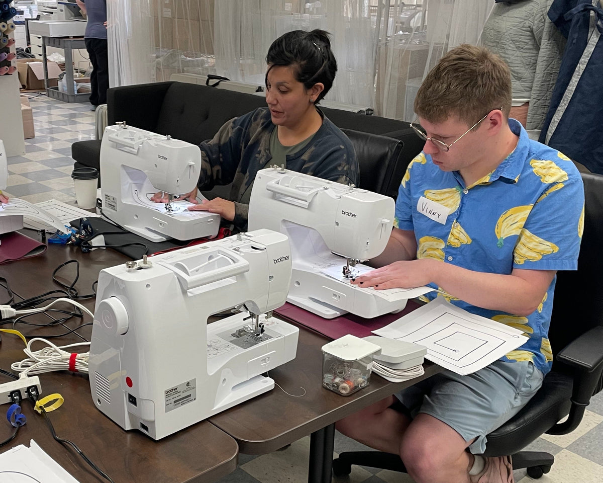 Co-workers sewing together during a corporate team building event at Unfold Den's Denver studio.