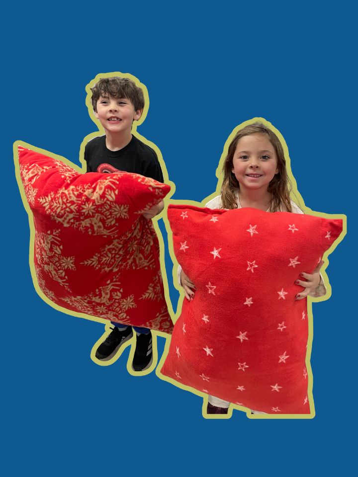 Two children holding red pillows with star patterns on a blue background | Sewing Birthday Parties in Denver | Unfold Den