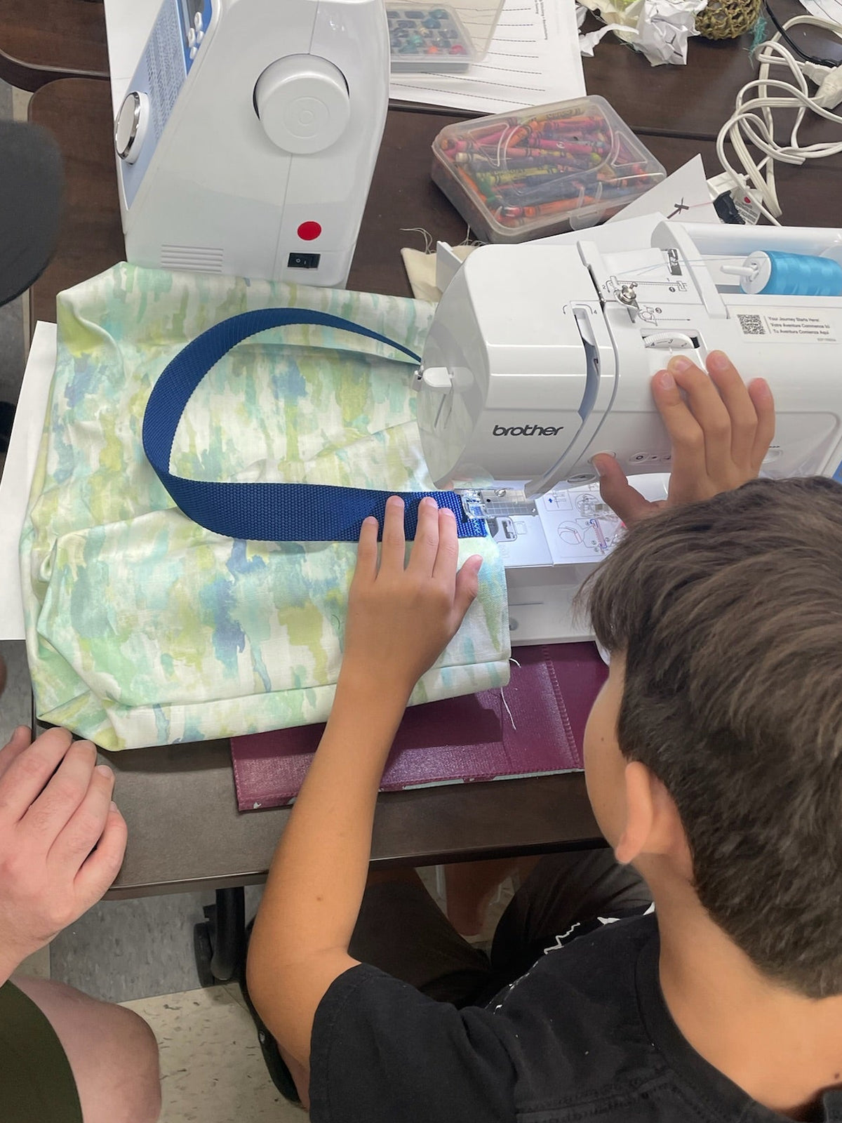 Kid sewing a tote bag during a sewing birthday party at Unfold Den in Denver